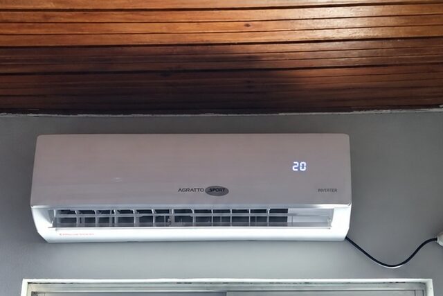 Unidade interna de ar-condicionado split instalada na parede de um cômodo, com o display aceso
